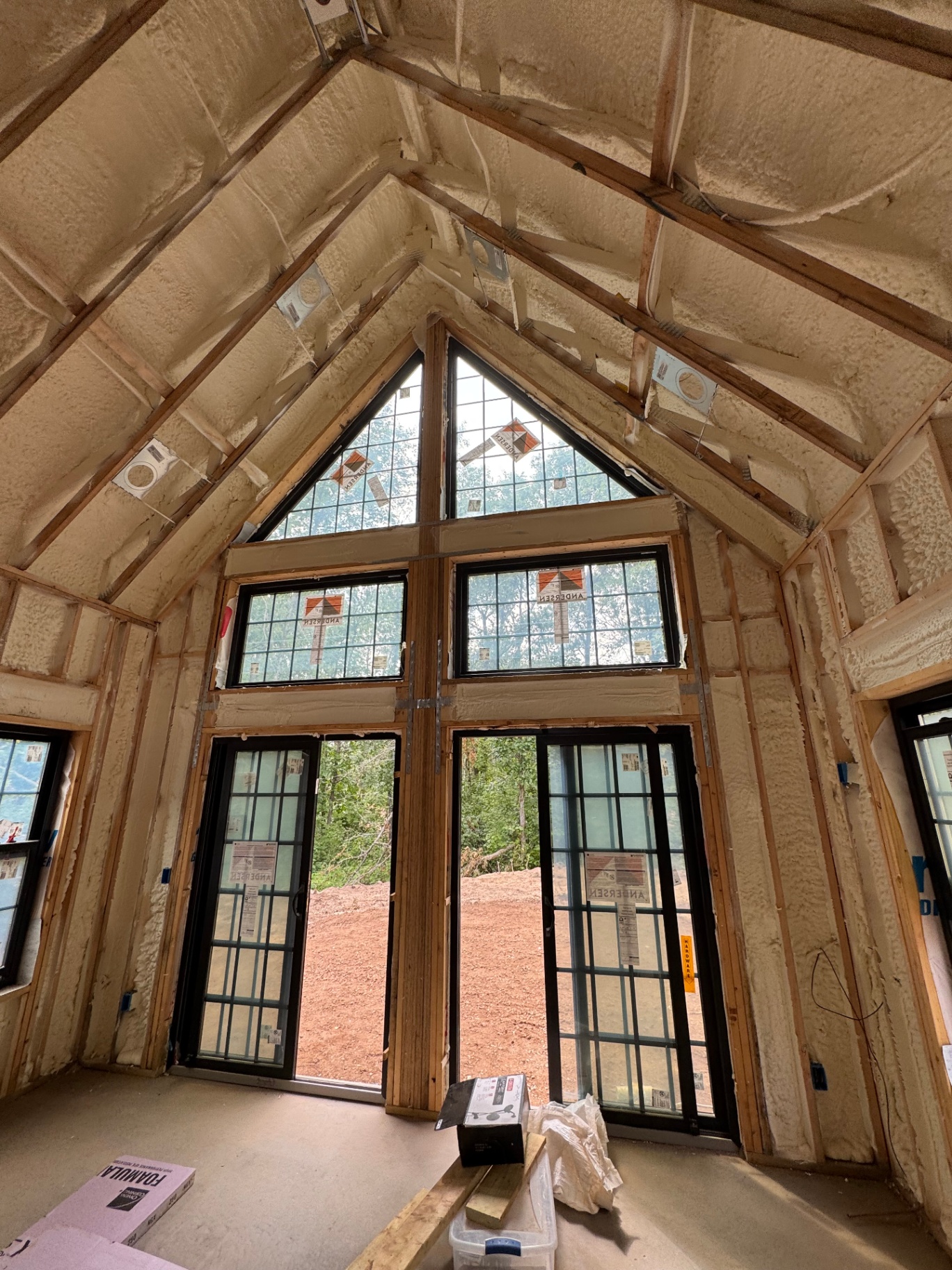 Cathedral ceiling and wall spray foam insulation around large picture windows in new construction